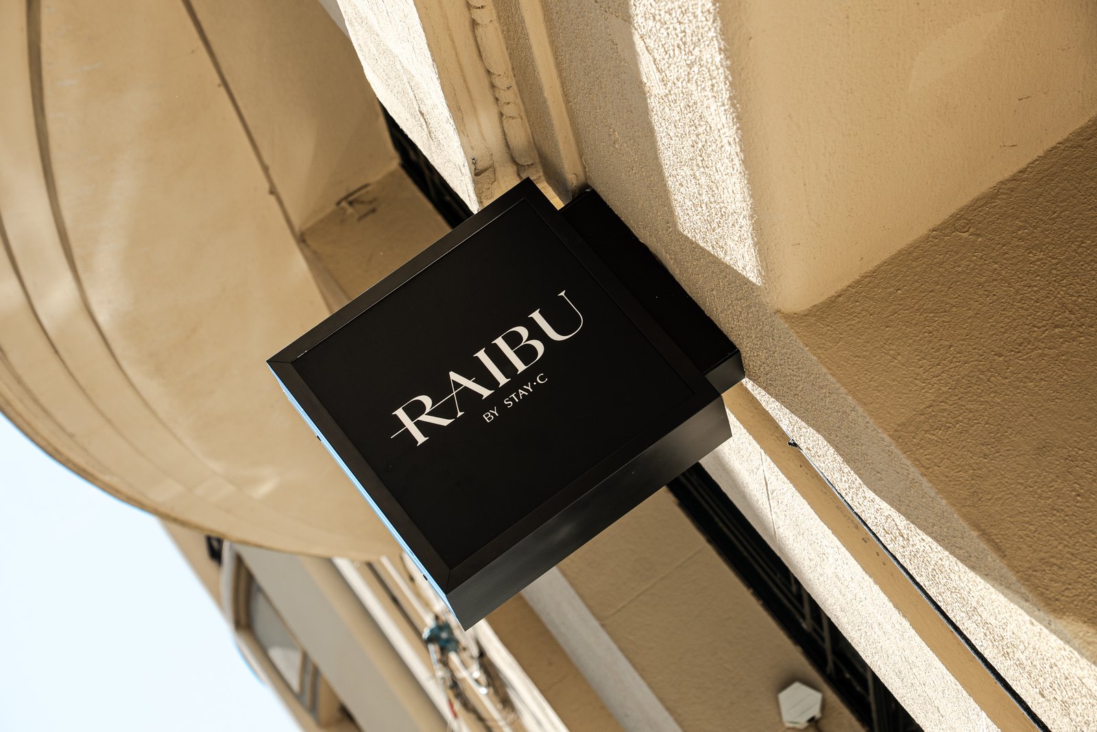 The RAIBU entrance sign against its sunlit facade
